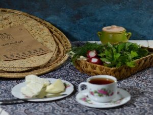 نان گندم کامل در کنار پنیر، کره و چای